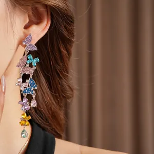 Vintage gold butterfly drop earrings with colorful zircon tassels worn by a model