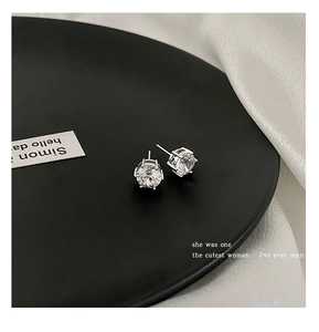 Detailed view of round sparkling zircon stud earrings with classic four-prong silver setting