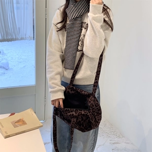 Grande borsa shopper leopardata in pelle scamosciata indossata da una modella