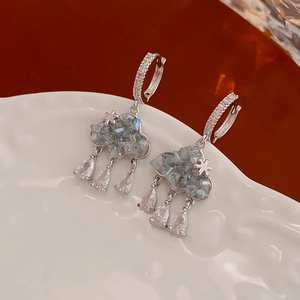 Vue détaillée de boucles d'oreilles nuage en argent avec cristaux bleus sur porcelaine