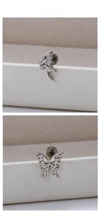 Macro view of butterfly stud earrings with zircon inlay on a textured display box