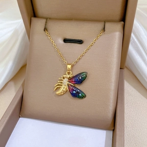 Macro view of bee pendant with colorful enamel wings and sparkling zircon inlay
