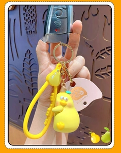 Close-up of cute yellow pear cartoon keychain with silicone strap and golden ring