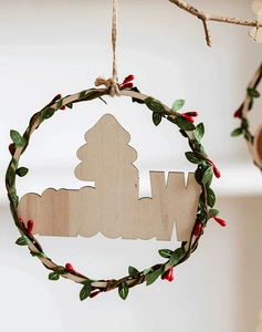 Detail of wooden Christmas wreath with laser-cut Welcome sign and red berry accents