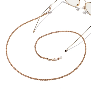 Detail of golden twisted metal glasses chain with lobster clasps and rubber loops
