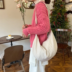 Detail of off-white pleated dumpling bag showing large capacity and soft texture