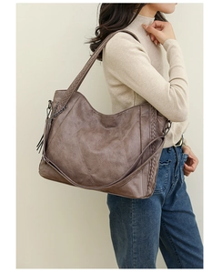 Brown PU leather hobo bag with geometric stitching and stylish tassel side charms