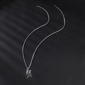 Long stainless steel necklace with a hollow pug pendant on a black leather surface