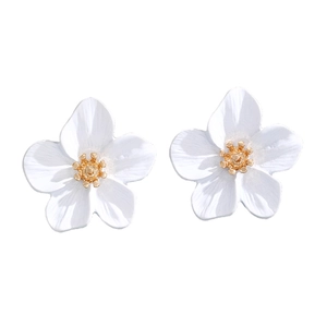 Macro view of white floral earrings with golden center pistil detail and matte finish