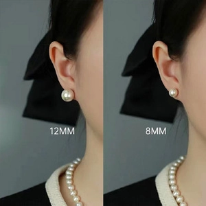 Detailed comparison of 8mm and 12mm round pearl earrings shown on a model's ear