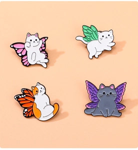 Vue détaillée de quatre jolies épingles en émail de chat avec des ailes de papillon