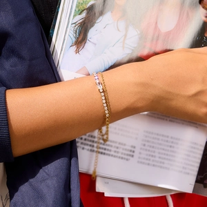 Detail of layered 18K gold stainless steel bracelet with zircon and colorful stones
