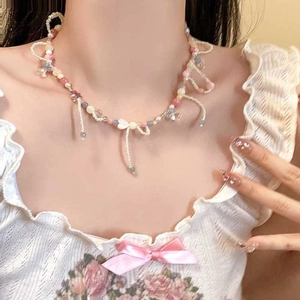 Gros plan d'un collier de perles colorées avec pendentif nœud et pompons sur le mannequin