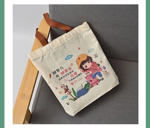Detail of canvas tote bag with colorful girl illustration and motivational text