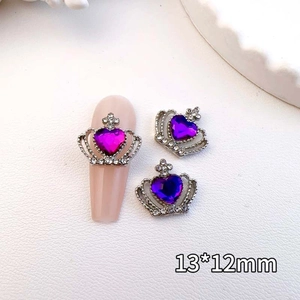 Macro detail of crown nail art charms with purple heart crystals and rhinestones
