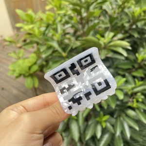 Detail einer Haarklammer aus Acryl mit kreativem schwarz-weißem QR-Code-Musterdesign