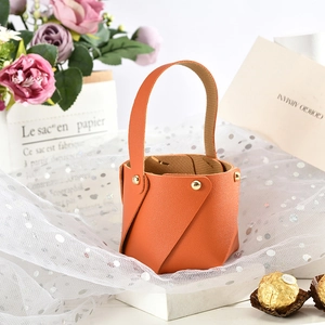 Detail of orange lychee grain leather wedding gift bag with gold rivet and handle