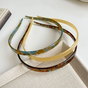 Detail van drie acetaat haarbanden in schildpad en beige op een display tray