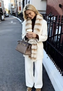 Street style view of white wool coat paired with a striped faux fur collar scarf