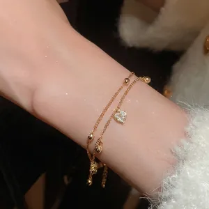 Double-layer 18k gold plated bracelet featuring zircon heart pendant on female wrist