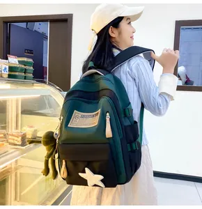 Detail of dark green contrast backpack with frog pendant and fashion bag label