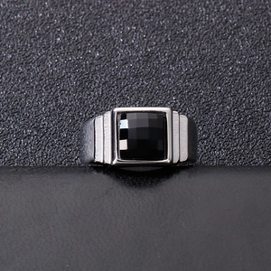 Macro detail of men's silver steel ring with faceted black square stone and grooved sides