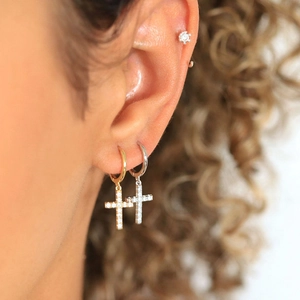 Close-up of gold and silver S925 cross hoop earrings with cubic zirconia on model