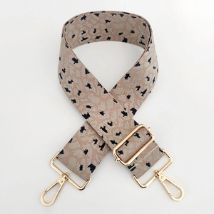Détails d'une bandoulière à motif léopard avec des mousquetons métalliques dorés polis