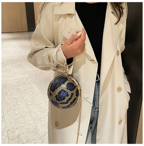 Detailed macro of a spherical sequin evening bag with blue leopard pattern and gold handle