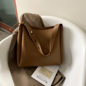Chic brown leather tote bag on a chair with artistic background for a minimalist style