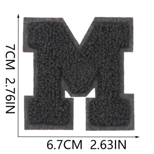 Macro view showing 7x6.7cm dimensions for black chenille letter M embroidered patch
