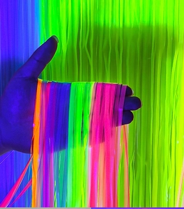 Close-up of vibrant neon fluorescent hair extensions in orange, purple, and pink