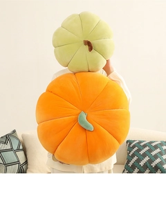 Detail of orange and light green corduroy pumpkin pillows showing ribbed texture and stems