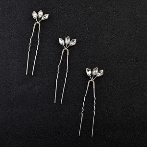 Three silver U-shaped hair pins with marquise rhinestones on a textured black background