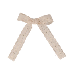 French lace bow hair clip in beige with delicate hollow embroidery on white background