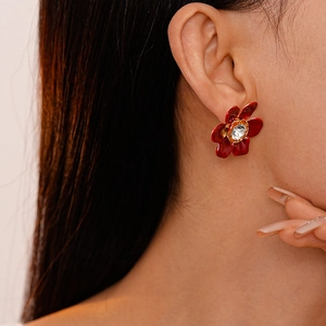 Elegant vintage red flower stud earrings with sparkling crystal center on model