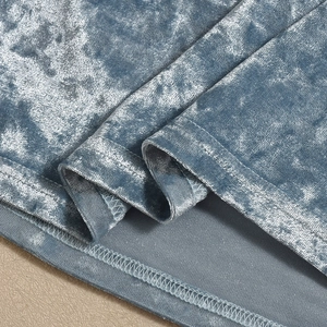 Detail van de zoomstiksels en de blauwe fluwelen stoftextuur van deze zomerjurk