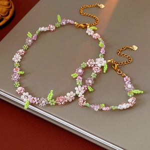 Detail of floral beaded necklace and bracelet set with pastel beads and heart charm