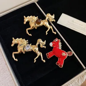 Exquisite horse brooches set in gold metal with rhinestones and red enamel details