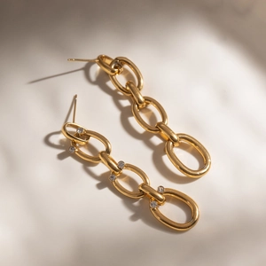 Boucles d'oreilles classiques en acier inoxydable 18K avec strass sur fond beige