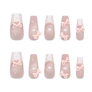 Pink cat-eye press-on nails with white polka dot French tips and pink 3D ribbon bows