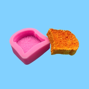 Pink silicone mold for toast-shaped bread and lifelike orange toast slice sample