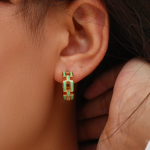 Detail of 18K gold-plated chain link earrings with mint green enamel on model