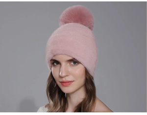 Détail du bonnet en tricot rose avec un gros pompon en fausse fourrure douce