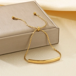 Detail of adjustable gold stainless steel bracelet featuring LOVER DREAM engraving