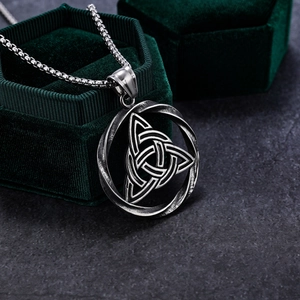 Close-up of vintage Celtic knot pendant in antique silver on green velvet jewelry box
