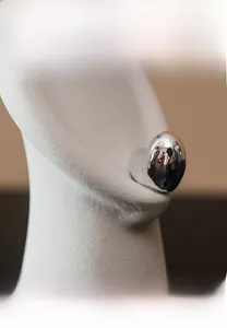Detailed side view of heart-shaped silver earrings on a model with polished finish