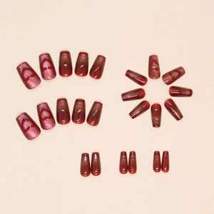 Macro shot of red cat eye press-on nails with glitter effect and heart patterns