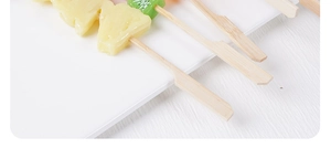 Close-up of decorative fruit skewers featuring resin pineapple and kiwi fruit topper