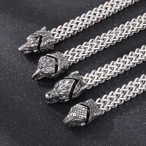 Detailed view of Viking style wolf, eagle, and snake pendants with woven steel chains